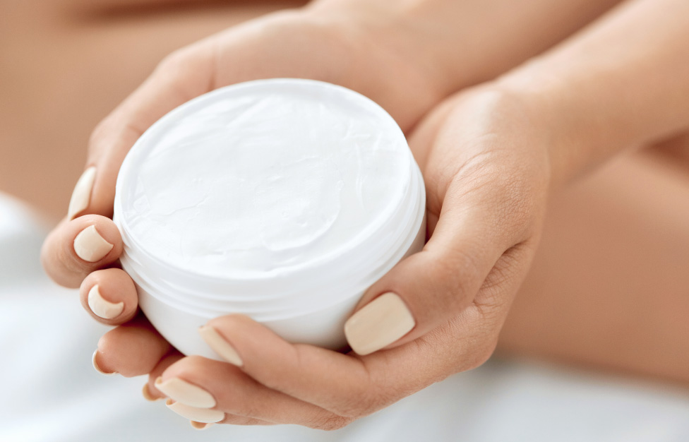 face cream close up in woman's manicured hands