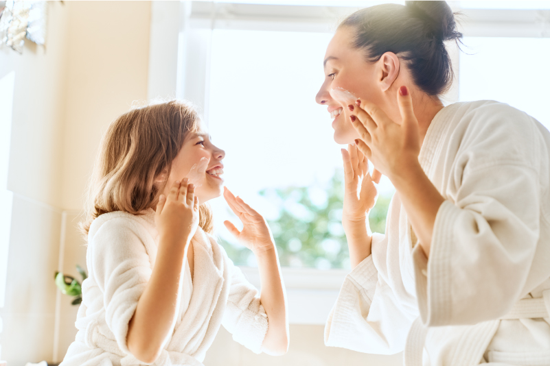 mother daughter applying face cream together